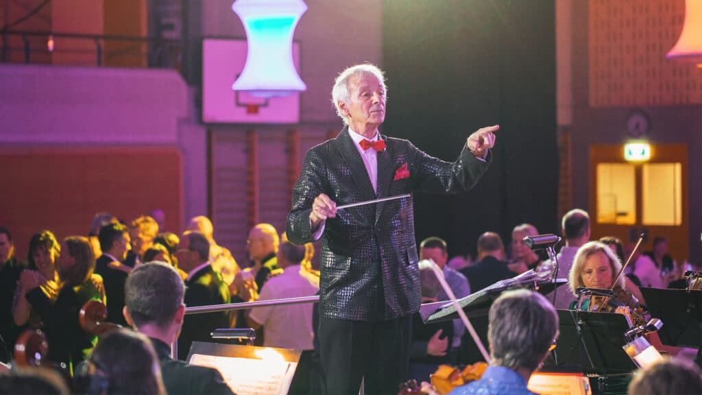 Dirigent leitet Orchester bei Konzertveranstaltung.