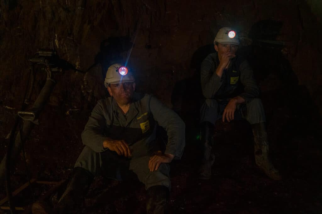 Bergarbeiter mit Helmlampen in einer Mine.